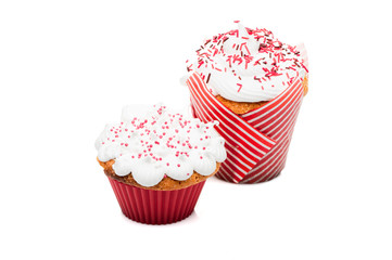 two cupcakes muffins with cream and red icing isolated at white background