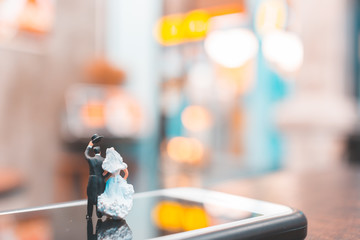 Miniature people , Couple standing on smartphone , love concept