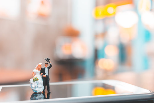 Miniature people , Couple standing on smartphone , love concept
