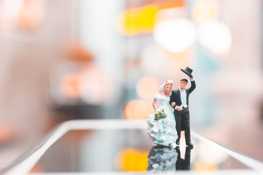 Miniature people , Couple standing on smartphone , love concept