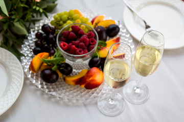 A table for two. Two glasses and a plate of fruit