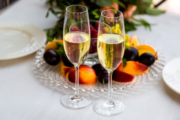 A table for two. Two glasses and a plate of fruit