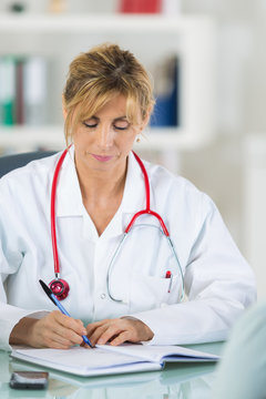 female doctor at her office writing something into her agenda