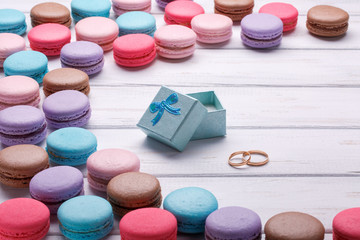 box with wedding rings and macaroon on white background.