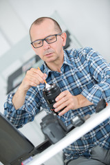 Man dusting camera lens