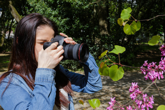young woman takes pictures of nature near the lake