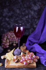 Ripe grapes and figs on dark wooden table