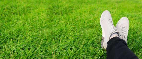 Female sneakers on legs in grass