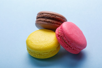 three mixed colorful macarons over gray background