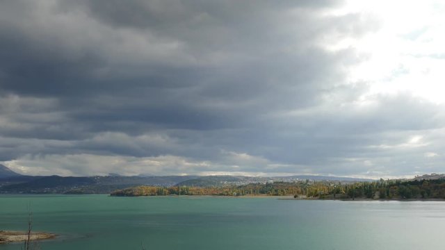 Autumn landscape with mountain lake / Lake and forested hills on background of sky with stormy clouds