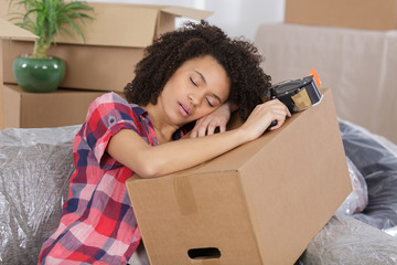 woman sleeping over package for house moving