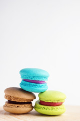 stack of Vibrant colorfull macarons on white wooden table. Text space