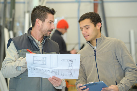 male engineer and worker checking indoor building construction site