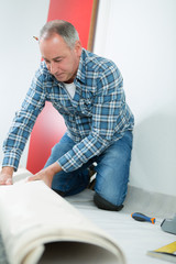 male worker unrolling carpet