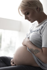 Severe pregnant woman hugging her tummy