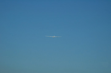 white glider on late afternoon blue sky