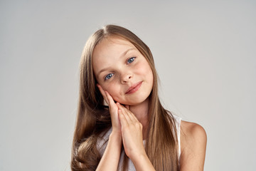 little girl with long hair on a light gray background, portrait