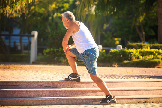 Man Does Morning Exercises Squats on Knee on Stone Steps