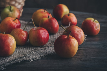 Fototapeta na wymiar Ripe red apples on an old wooden table and linen napkin.