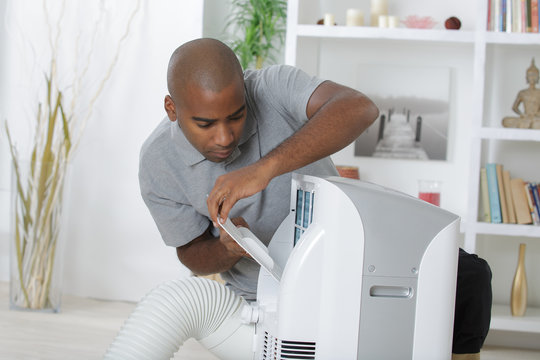 Man working on residential air conditioner