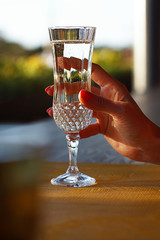  the girl holds a crystal glass with prosecco or sparkling wine in her hand