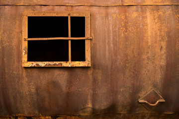 Window in an iron wall on a rusty background