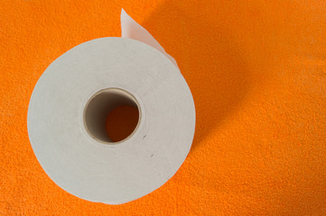 Roll of toilet paper on an orange towel