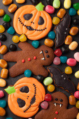 Fototapeta na wymiar Halloween pumpkin, bat and gingerbread man-vampire cookies and colorful candy overhead shot