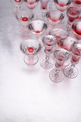 Drinking glasses with alcohol on grey metal table with copy space