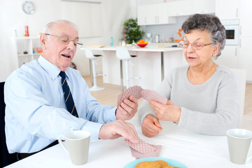 retired couple playing cards at home