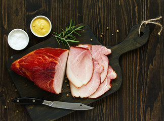 Homemade smoked ham, sliced. View from above. Dark background. © ld1976