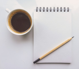 A notebook, a pencil, a Cup of coffee on a white background. Top view 