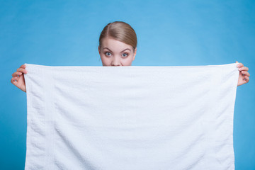 Woman hiding behind big white clean towel