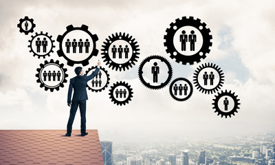 Businessman on house roof presenting teamwork and connection con