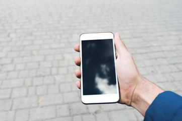 The human hand is using the smart phone. Winter time. Concept waiting or meeting