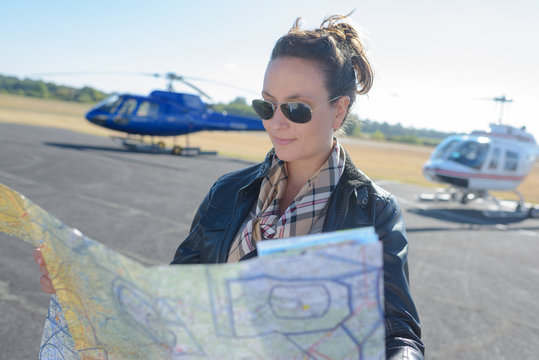 young woman helicopter pilot reading map
