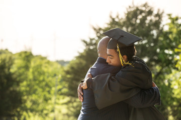 Father hugging his son at his graduation.