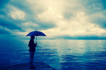 Frau am Strand im Regen