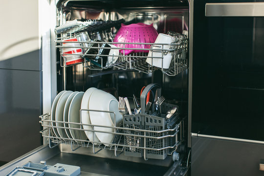 Cleaned dishes in open dishwasher.