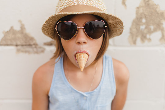 Serious face girl with ice cream cone in mouth
