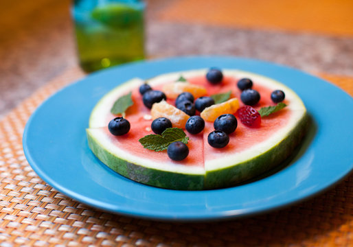 Watermelon cut like pizza with fresh fruit on top