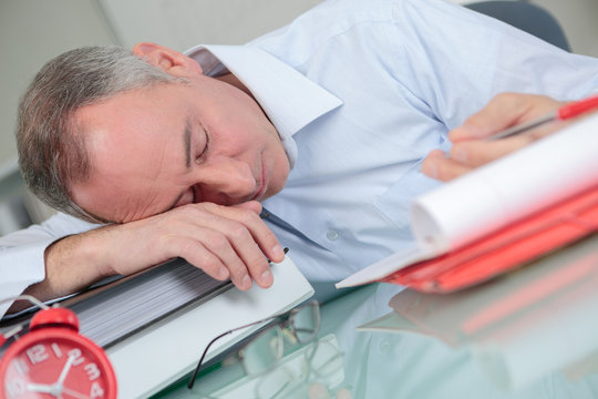 stressed overworked man studying sleepy on desk