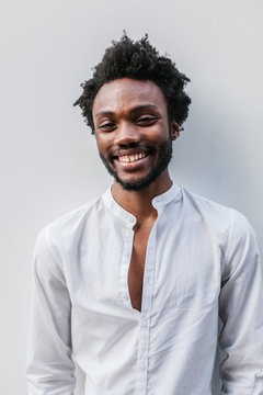 Afro American Man Smiling Over a White Wall