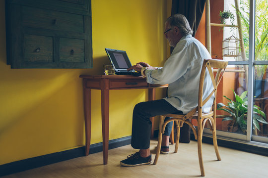 Old Man Working on a Laptop at Home