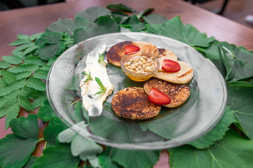 Pancakes with strawberries and nuts on a table with flowers