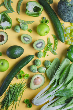 Green vege and fruits on yellow background