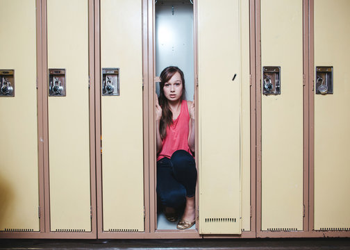 Scared high school student hiding inside locker