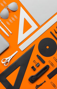 Office supplies and stuff arranged on orange backgorund.