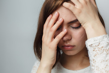 A young girl holds her hands behind her head, problems