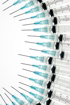 Closeup of a group of hypodermic needles pointing to the same general point in space.